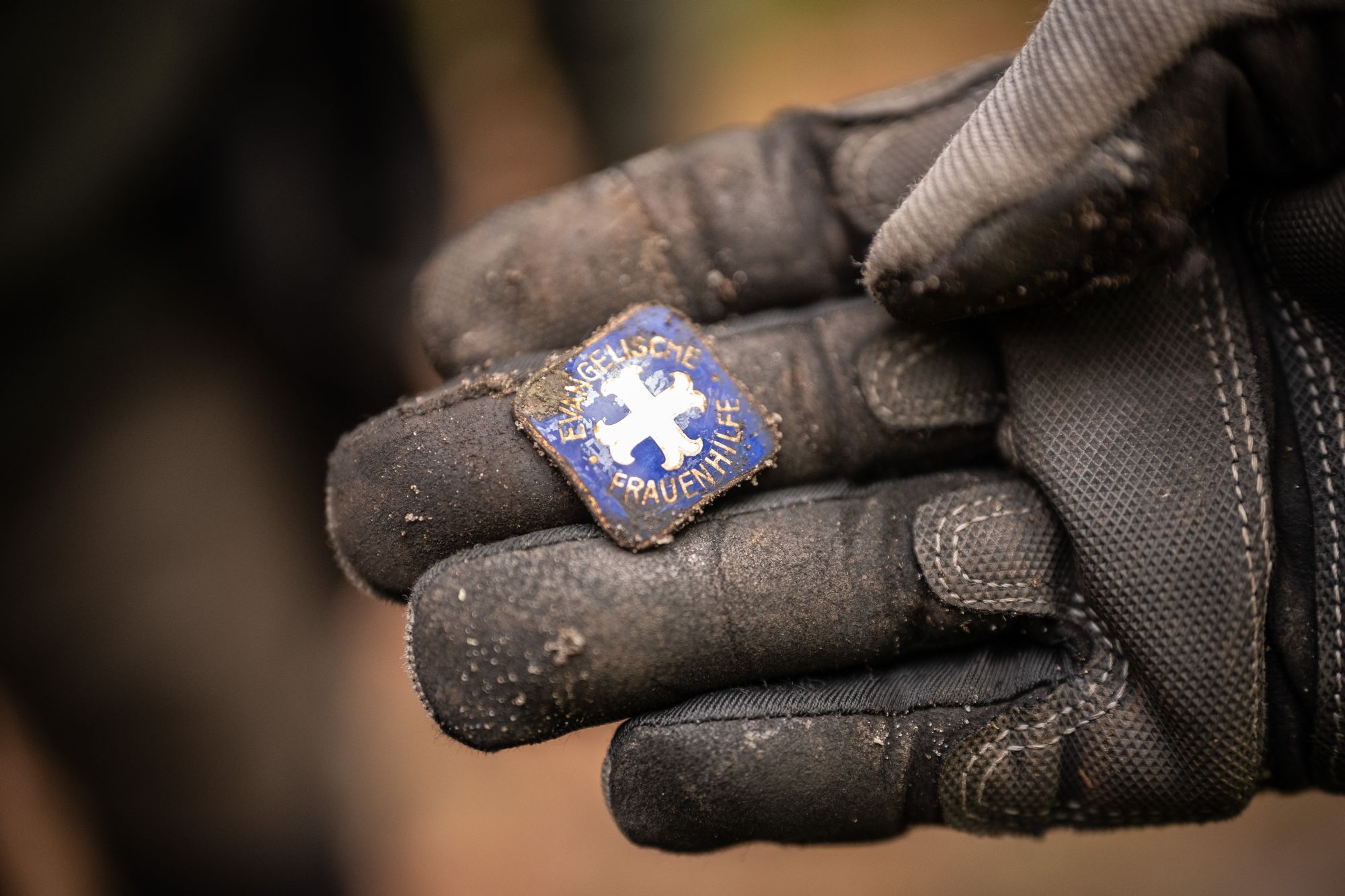 Hand, die ein Emblem mit der Aufschrift „Evangelische Frauenhilfe“ zeigt