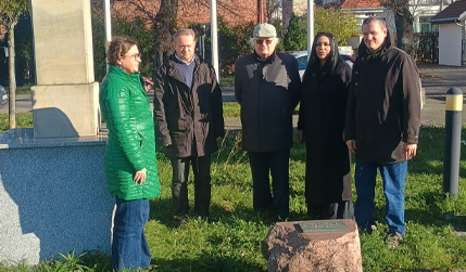 Die Mitarbeiter legen vor dem Denkmal zum 100. Jahrestag der Wiedererlangung der Unabhängigkeit Blumen nieder