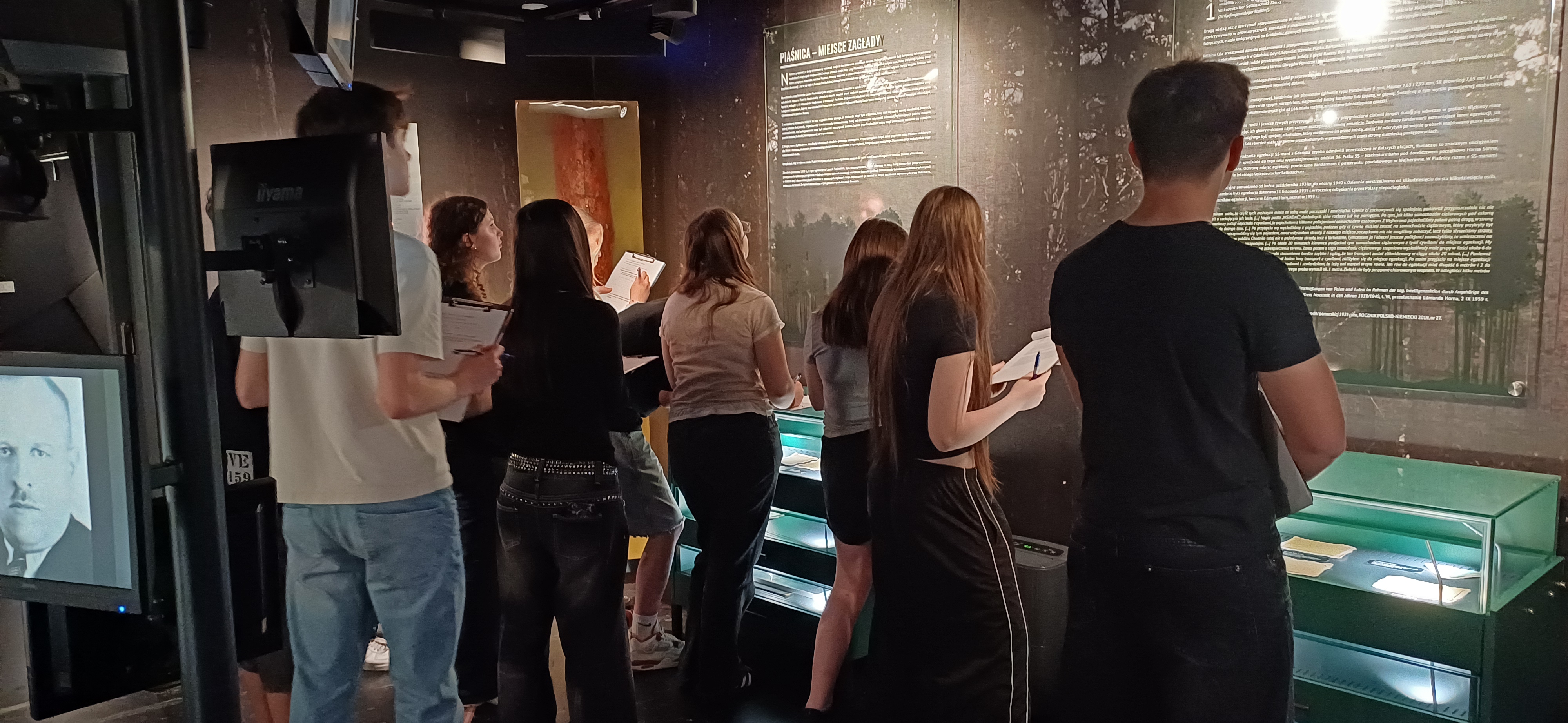 grupa ludzi ogląda wystawę stałą w Muzeum Piaśnickim