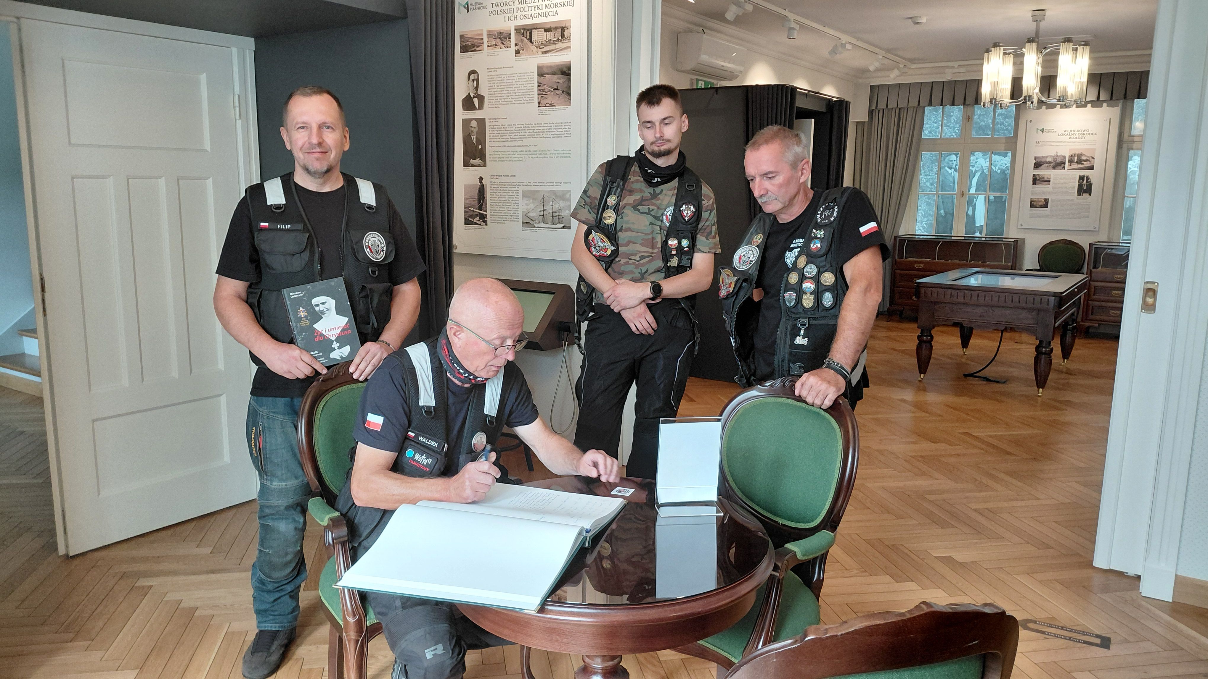 motocykliści wpisują się do księgi pamiątkowej w Muzeum Piaśnickim