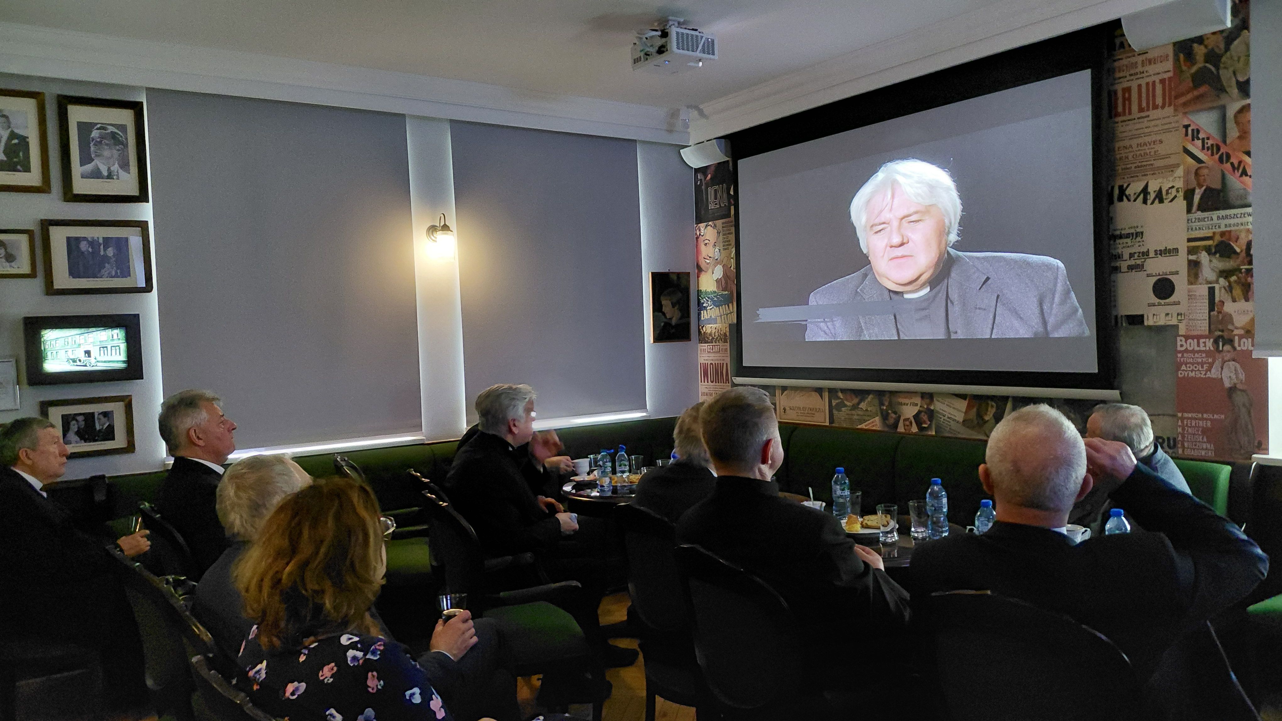 księża oglądają film o Piaśnicy w czytelni